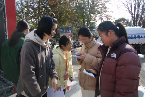 图一 志愿者为同学介绍“善行100”活动.JPG