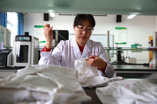 b0a385534f274f6d94288c152ac1bfcd.jpg 刘瑞芳老师在缝补实验服袖口_副本.jpg